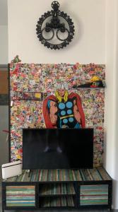 una TV in un soggiorno con un murale di supereroi di Ercolano City Center a Ercolano