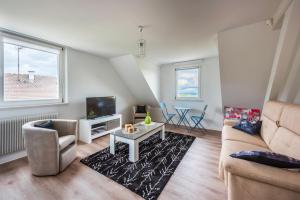 a living room with a couch and a table at Gite Les deux belettes in Riquewihr