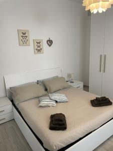 une chambre blanche avec un lit avec deux serviettes dessus dans l'établissement civico 18, à Moneglia