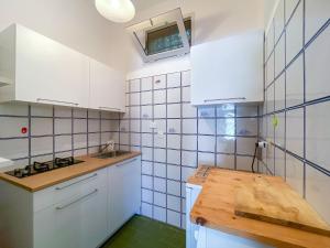 une cuisine avec des placards blancs et une table en bois dans l'établissement Appartamento Il Faro 2, à Rio nellʼElba