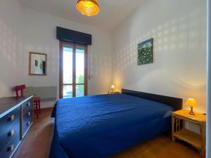 a bedroom with a blue bed and a window at Appartamento Il Faro 2 in Rio nellʼElba