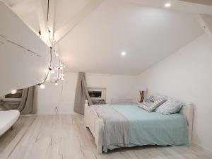 a white bedroom with a bed and a bathroom at Immeuble Centre Ville in Saint-Médard-de-Guizières