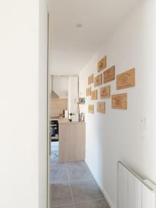 Immeuble Centre Ville في Saint-Médard-de-Guizières: مطبخ بجدران بيضاء وممر به لافتات خشبية على الحائط