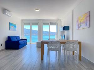 a living room with a dining room table and a blue couch at Appartamento Fronte Mare 20 in Portoferraio