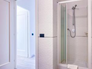 una doccia con una porta in vetro in un bagno di Appartamento Fronte Mare 20 a Portoferraio Altre 7 foto