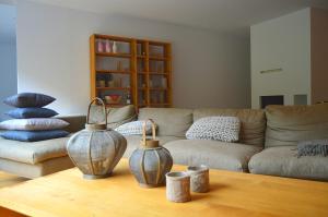 a living room with a couch and two vases on a table at Schooren des Alpes - Apartment LES CAVES DU ROI- TOP 1 in Kappl