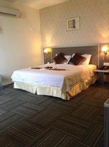 Bagan Serai的住宿－K Garden Hotel (BS)，酒店客房配有一张带白色床单和枕头的大床。
