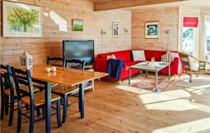 un soggiorno con divano rosso e tavolo di Cozy Home In Sndeled With Kitchen a Søndeled