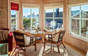 una stanza con due sedie e un tavolo e finestre di Cozy Home In Sndeled With Kitchen a Søndeled