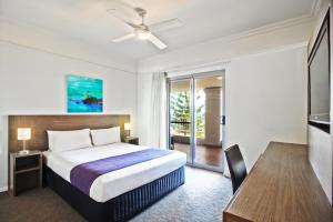 
a hotel room with a bed, chair and a window at Cottesloe Beach Hotel in Perth

