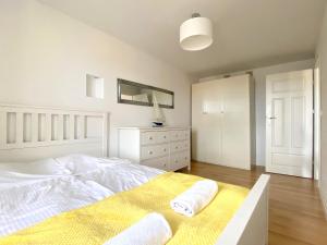 - une chambre blanche avec un lit et une commode dans l'établissement Grand Apartments - Apartament Surfer w centrum Sopotu, à Sopot