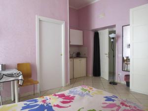 a bedroom with pink walls and a bed and a table at BB Augusteo in Naples