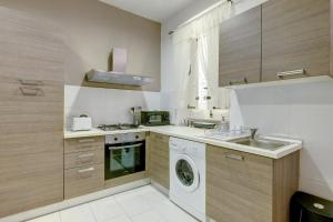 a kitchen with a washing machine and a sink at Modern 1BR Maisonette steps from the Promenade in Sliema