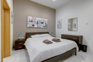 a bedroom with a bed with two towels on it at Modern 1BR Maisonette steps from the Promenade in Sliema +38 photos