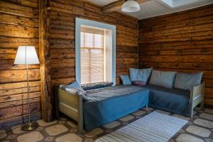 - une chambre avec un lit dans une cabane en rondins dans l'établissement Nopri puhkemaja, à Tsiistre