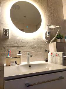 a bathroom with a sink and a large mirror at Zagreb4you Apartments in Zagreb