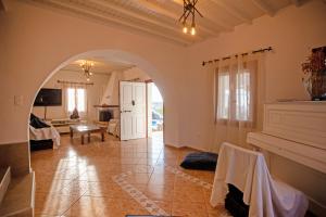 een grote woonkamer met een boog en een woonkamer bij Villa Dimitra in Ano Mera