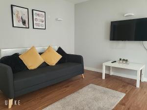 - un salon avec un canapé noir et une table blanche dans l'établissement Luxury City Apartment in JQuarter Birmingham, à Birmingham