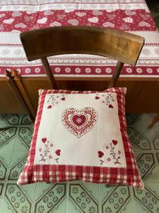 a pillow with a heart on it sitting on a chair at Lander Residence in Piano dʼArta