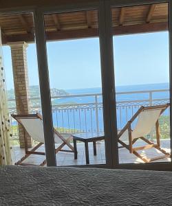 a room with a balcony with a table and chairs at Village House Kalypso in Paleokastritsa