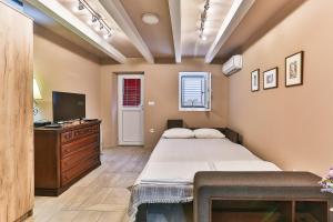 a bedroom with two beds and a desk and a television at Magnolia Lux Apartments in Budva