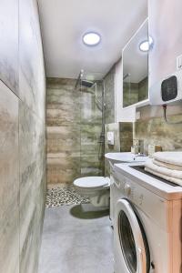 a bathroom with a washing machine and a toilet at Magnolia Lux Apartments in Budva