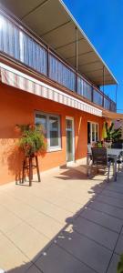 ein Gebäude mit einer Terrasse mit einem Tisch und Bänken in der Unterkunft Apartments Skorup in Ičići