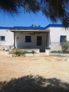 a white house with a blue roof at Fabrika's Breeze in Vári