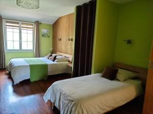 two beds in a room with green walls at Au Saint-Amand in Poissons