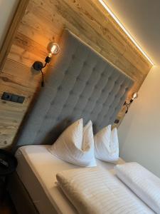 a bed with a headboard with two pillows on it at Das Anja Alt Filzmoos in Filzmoos
