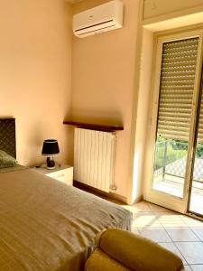 a bedroom with a bed and a window with a fan at La Divina in Cosenza