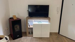 sala de estar con TV y armario blanco en La Dependance al Piccolo Borgo, en Crispiano