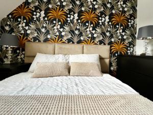 a bedroom with a bed with a black and white wallpaper at Apartamenty Villa Fiori in Sobieszewska Pastwa