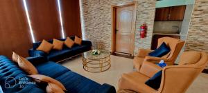 - un salon avec un canapé bleu et des chaises dans l'établissement دلتا بارك للشقق المخدومة DELTA PARK SERVICED APARTMENTs, à Riyad