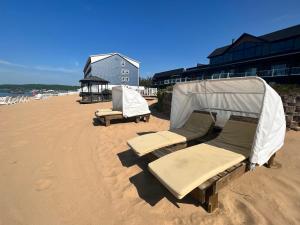 特拉弗斯城的住宿－海灘酒店- 特拉弗斯城，海滩上摆放着几把椅子和帐篷