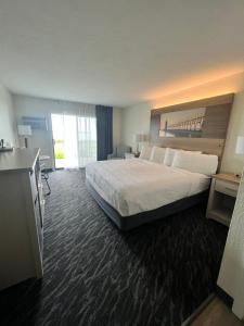 a hotel room with a large bed and a television at The Beach Haus - Traverse City in Traverse City