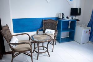 a room with two chairs and a table and a tv at B&B JPA Casa ANSELMO in Salvador