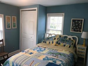 柏林的住宿－BEACH HAVEN Dog friendly farmette Great for 2 couples，一间卧室设有一张床和蓝色的墙壁