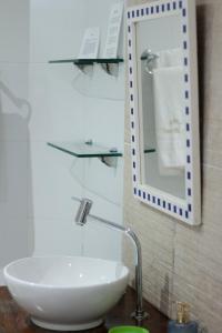a bathroom with a white sink and a mirror at B&B JPA Casa ANSELMO in Salvador