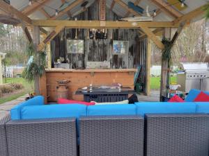 - un salon avec un canapé bleu dans un pavillon dans l'établissement BEACH HAVEN Dog friendly farmette Great for 2 couples, à Berlin