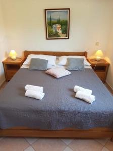 a bedroom with a large bed with two pillows at Apartments Kala in Sveti Filip i Jakov