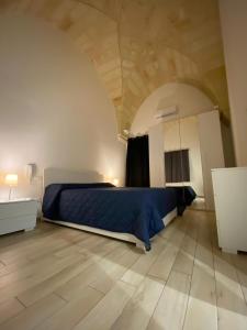 a bedroom with a bed with a blue comforter at IMPERIAL APP. Terrace & more in Pisignano