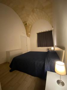 a bedroom with a black bed and a table with a lamp at IMPERIAL APP. Terrace & more in Pisignano