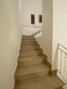 a staircase in a white building with wooden steps at IMPERIAL APP. Terrace & more in Pisignano