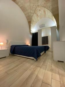 a bedroom with a bed in a large room with a wooden floor at IMPERIAL APP. Terrace & more in Pisignano