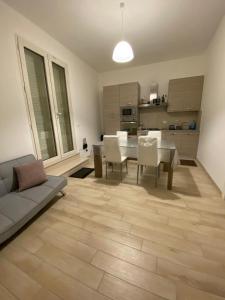 a living room with a table and chairs and a kitchen at IMPERIAL APP. Terrace & more in Pisignano
