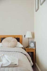 um quarto com uma cama e um relógio numa mesa de cabeceira em The Jolly Drover em Liss