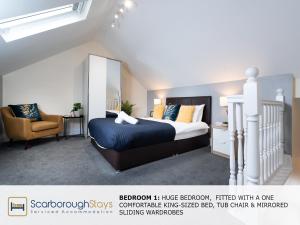 um quarto com uma cama com um espelho e uma cadeira em Scarborough Stays - Ashville Lodge - 5 Bedroomed house - Sleeps 9 em Scarborough