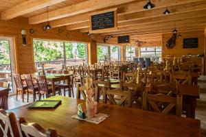 a dining room with wooden tables and chairs at Chata pod Ostrým vrchom in Soblahov