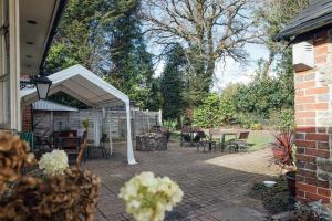 a patio with a white canopy and tables and chairs at The Jolly Drover in Liss